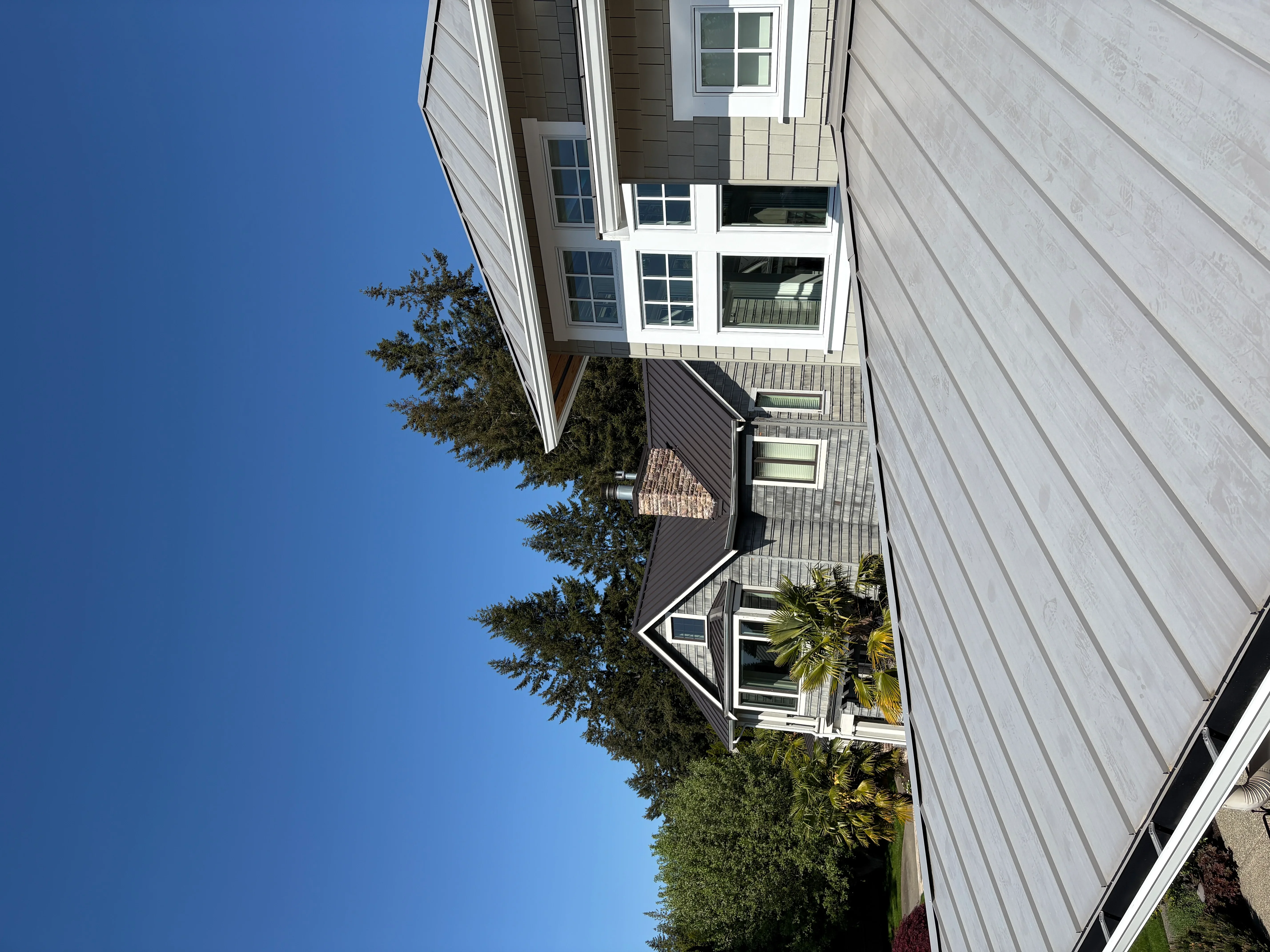 Modern home with vertical metal siding and brick chimney after pressure washing service
