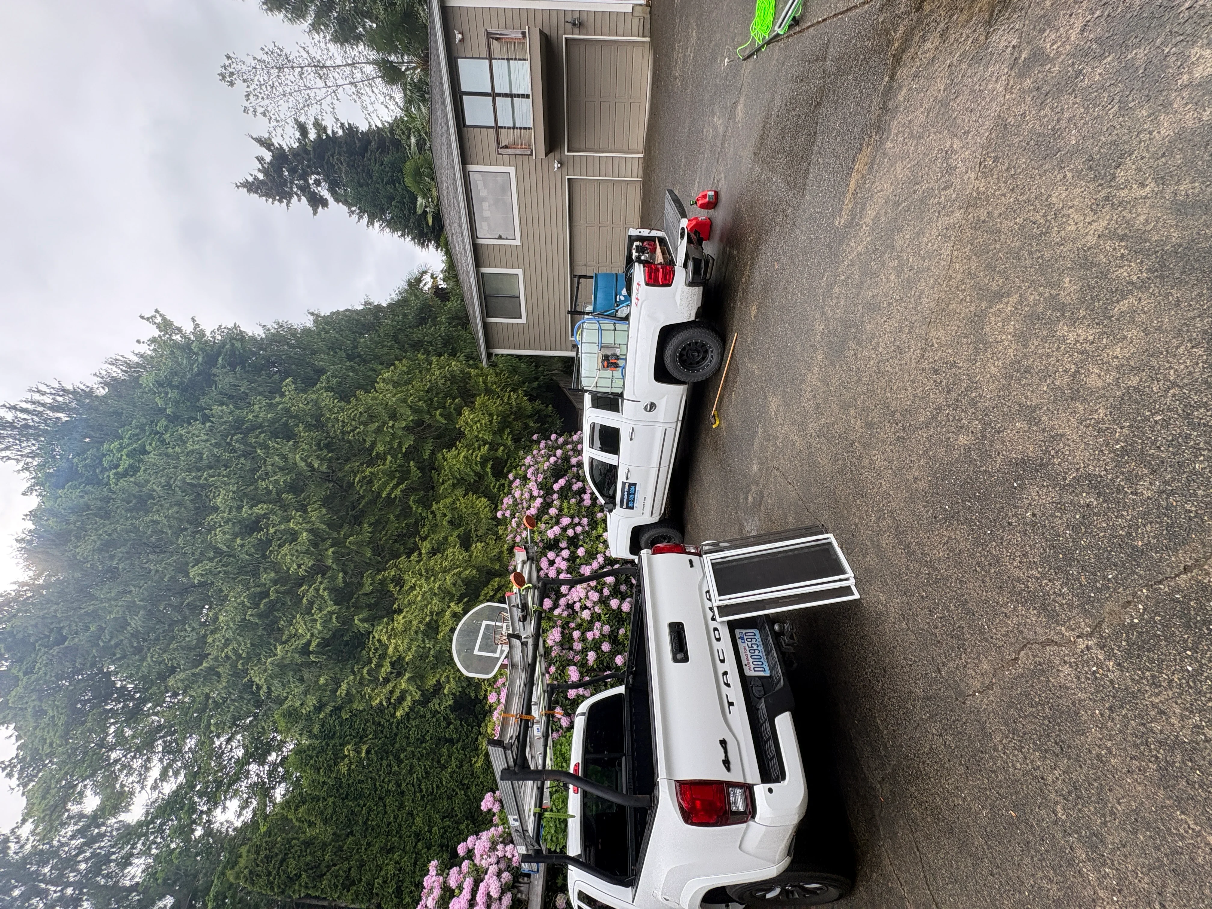 Pressure-washed asphalt driveway with clean surface and professional equipment on site