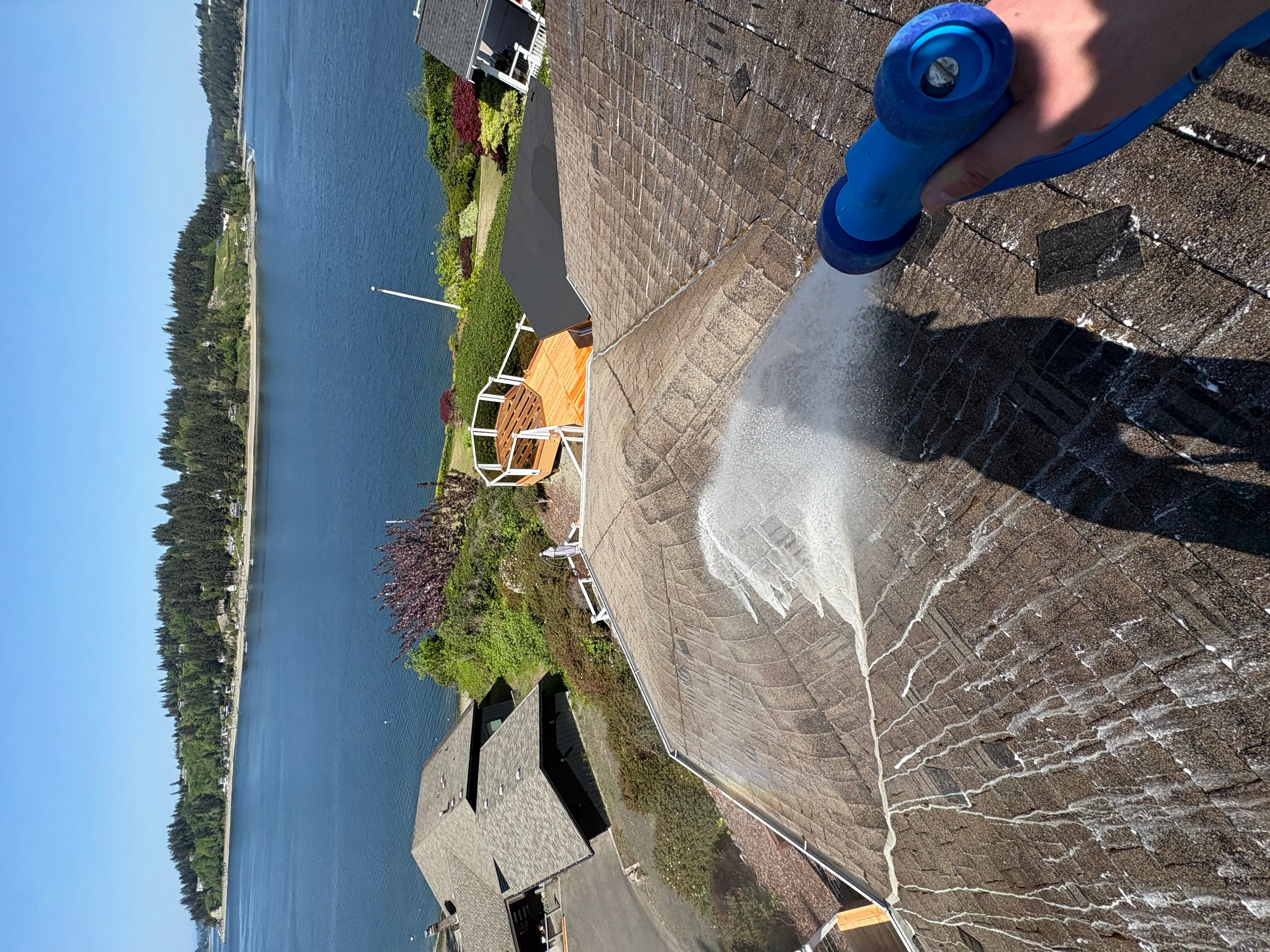 Pressure washing residential driveway concrete surface with cleaning equipment